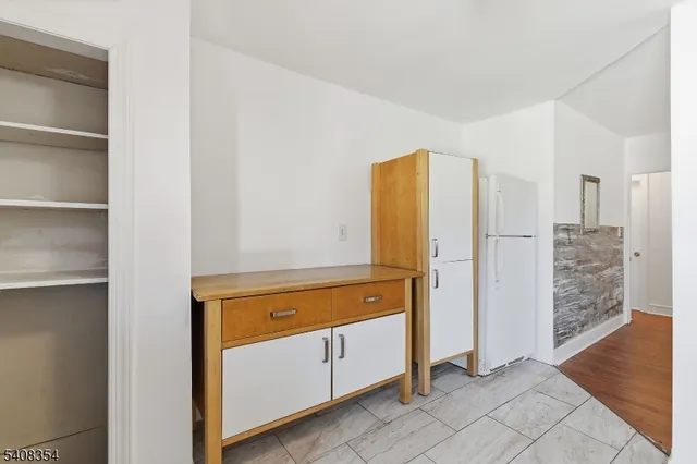 a view of a kitchen with refrigerator and wooden floor