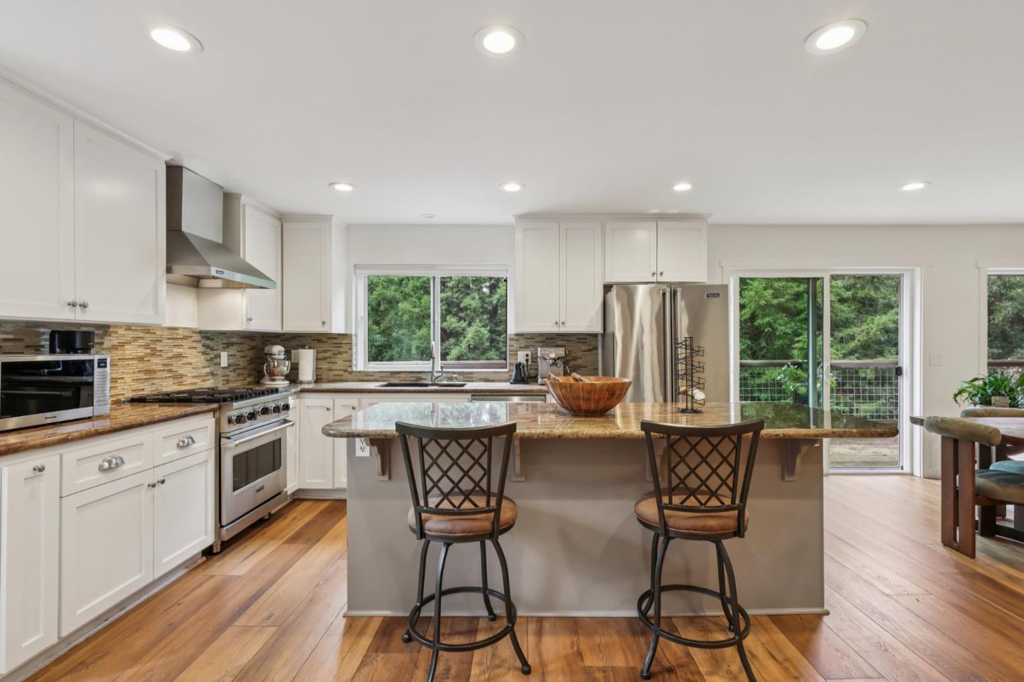 17386 Tressel Pass Road Boulder Creek, CA 95006 - Photo 9 of 41 a kitchen with stainless steel appliances granite countertop a stove top oven a sink dishwasher a dining table and chairs with wooden floor