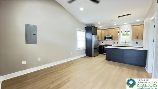 a view of kitchen with stainless steel appliances refrigerator sink and cabinets
