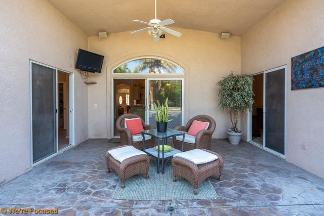 a living room with patio furniture and a chandelier