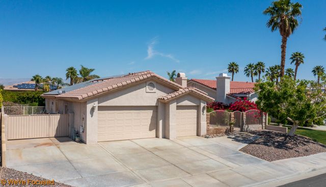 a view of a house with a yard and potted plants