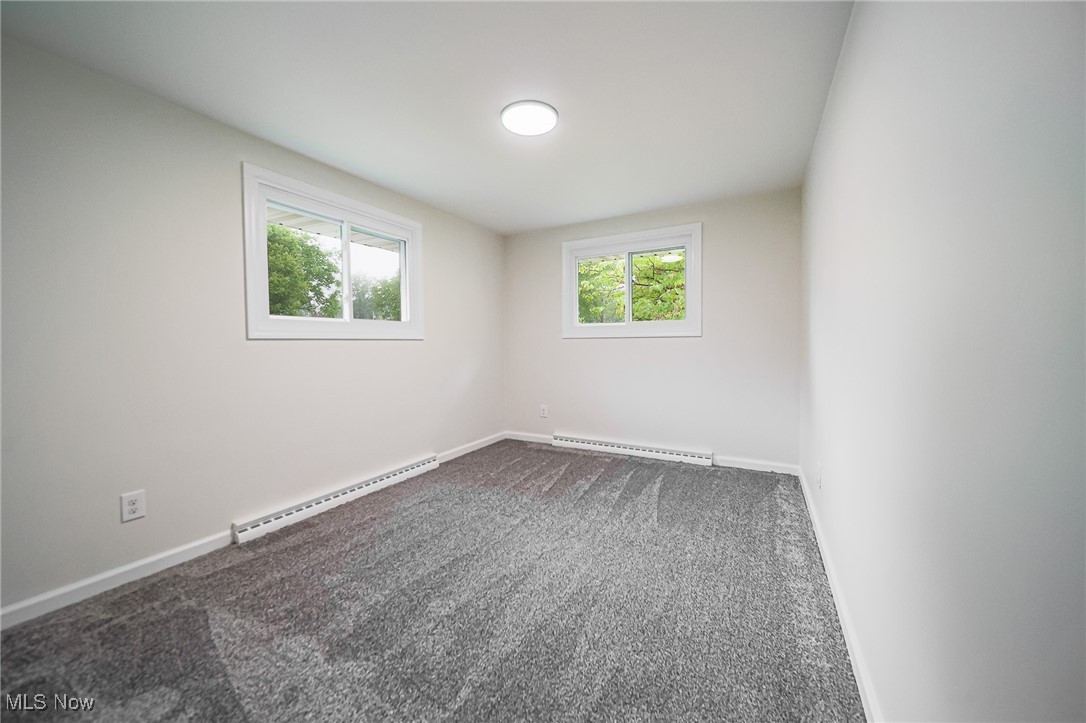 55 Elm Street Rittman, OH 44270 - Photo 28 of 46 Spare room featuring a baseboard radiator, dark colored carpet, and baseboards