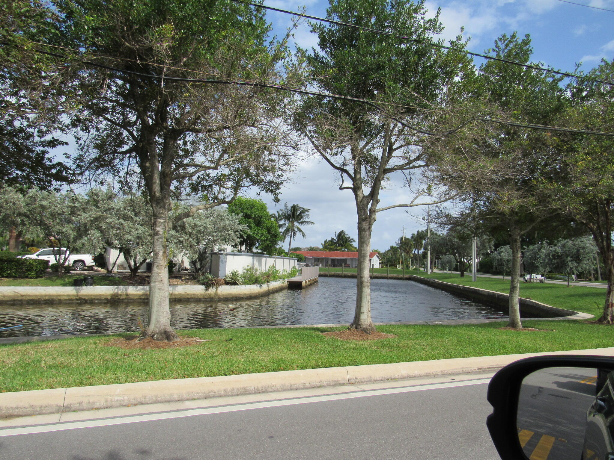 1911 Northeast 27th Court, Unit 13 Lighthouse Point, FL 33064 - Photo 56 of 61 a backyard of a house with lots of green space and fountain