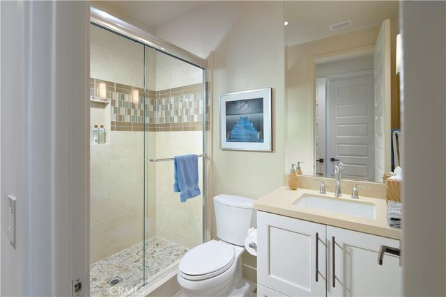 a bathroom with a sink a toilet a mirror and shower