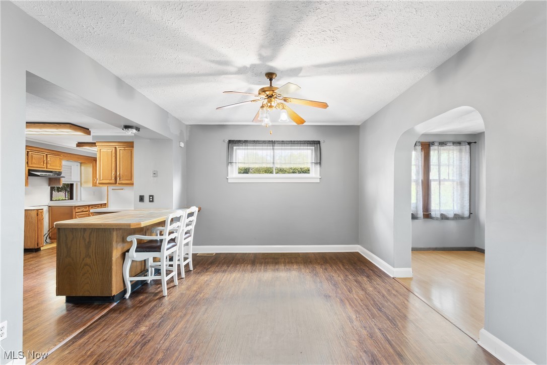 302 Poplar Avenue Northwest Canton, OH 44708 - Photo 8 of 34 Dining area featuring dark wood-style floors, arched walkways, a ceiling fan, and a textured ceiling