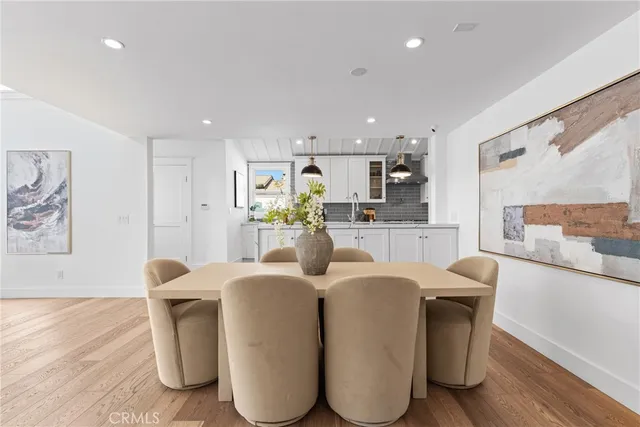a living room with stainless steel appliances kitchen island granite countertop furniture and a wooden floor