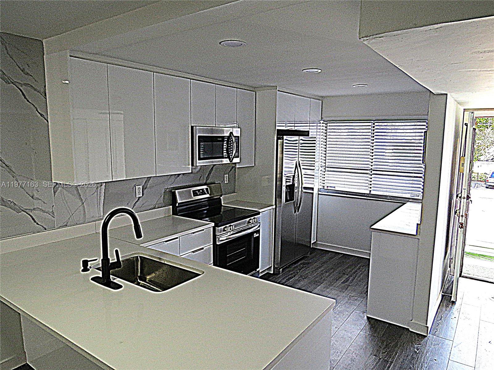 3591 Inverrary Drive, Unit 203 Lauderhill, FL 33319 - Photo 1 of 12 a kitchen with a sink stainless steel appliances and cabinets