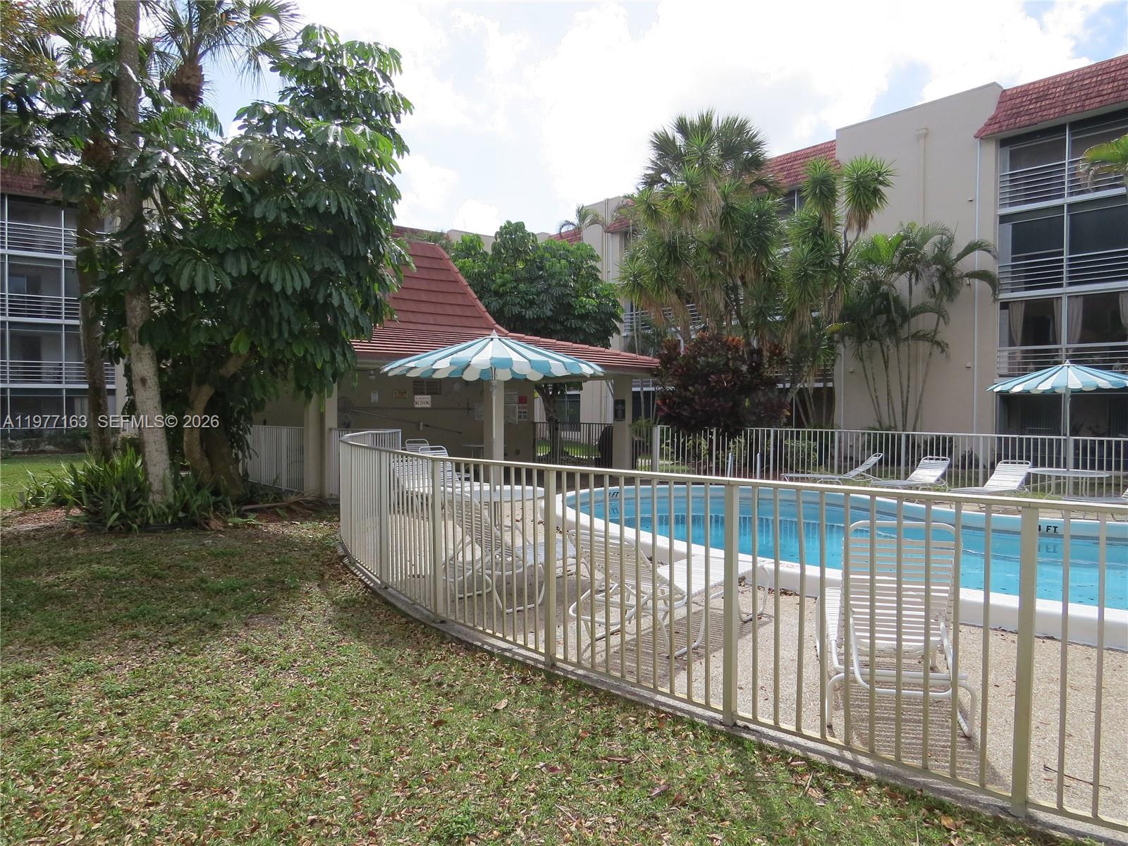 3591 Inverrary Drive, Unit 203 Lauderhill, FL 33319 - Photo 12 of 12 a view of house with a small yard and wooden fence
