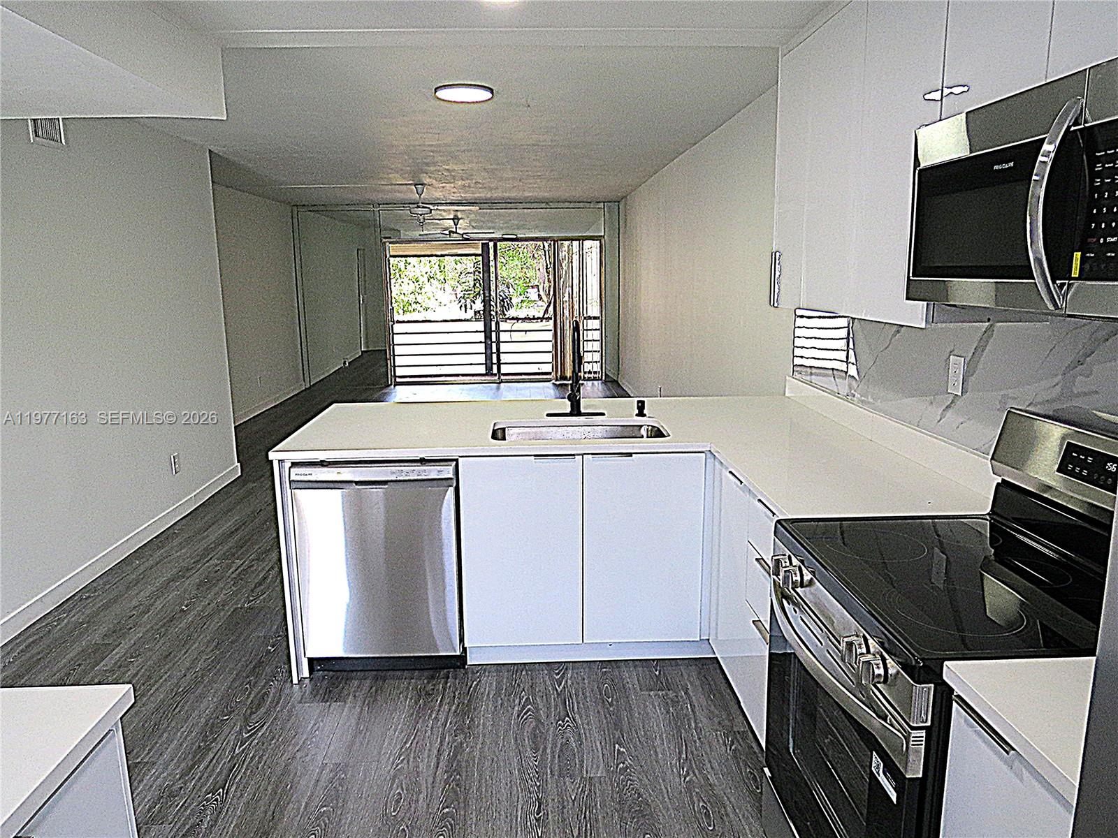 3591 Inverrary Drive, Unit 203 Lauderhill, FL 33319 - Photo 2 of 12 a utility room with wooden floor washer and dryer