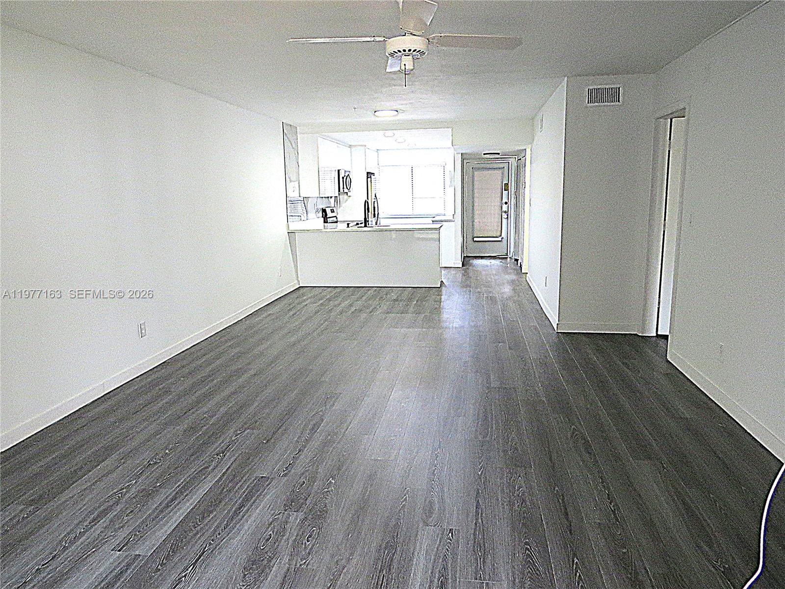3591 Inverrary Drive, Unit 203 Lauderhill, FL 33319 - Photo 3 of 12 wooden floor in an empty room with a window