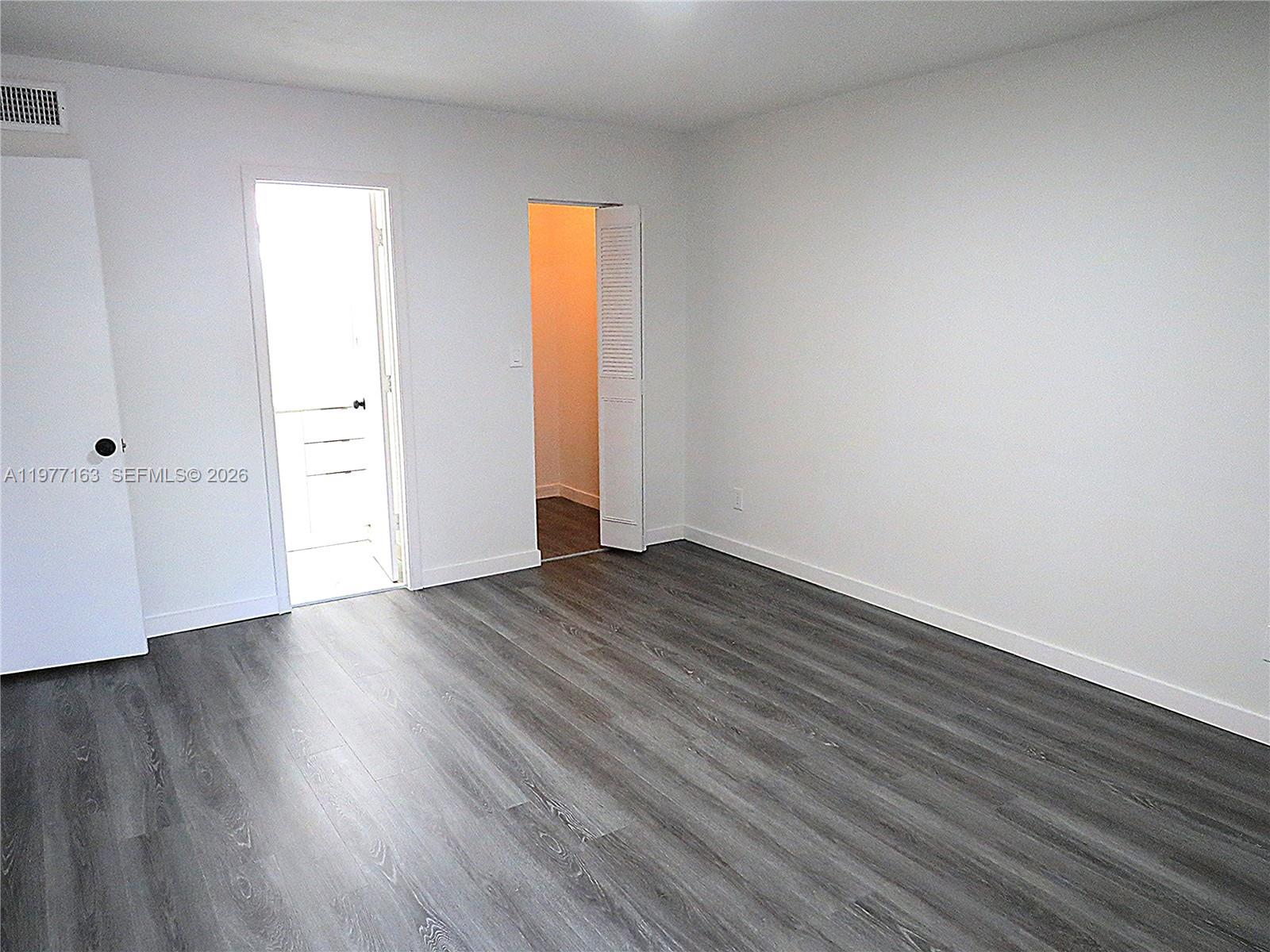 3591 Inverrary Drive, Unit 203 Lauderhill, FL 33319 - Photo 6 of 12 an empty room with wooden floor and closet