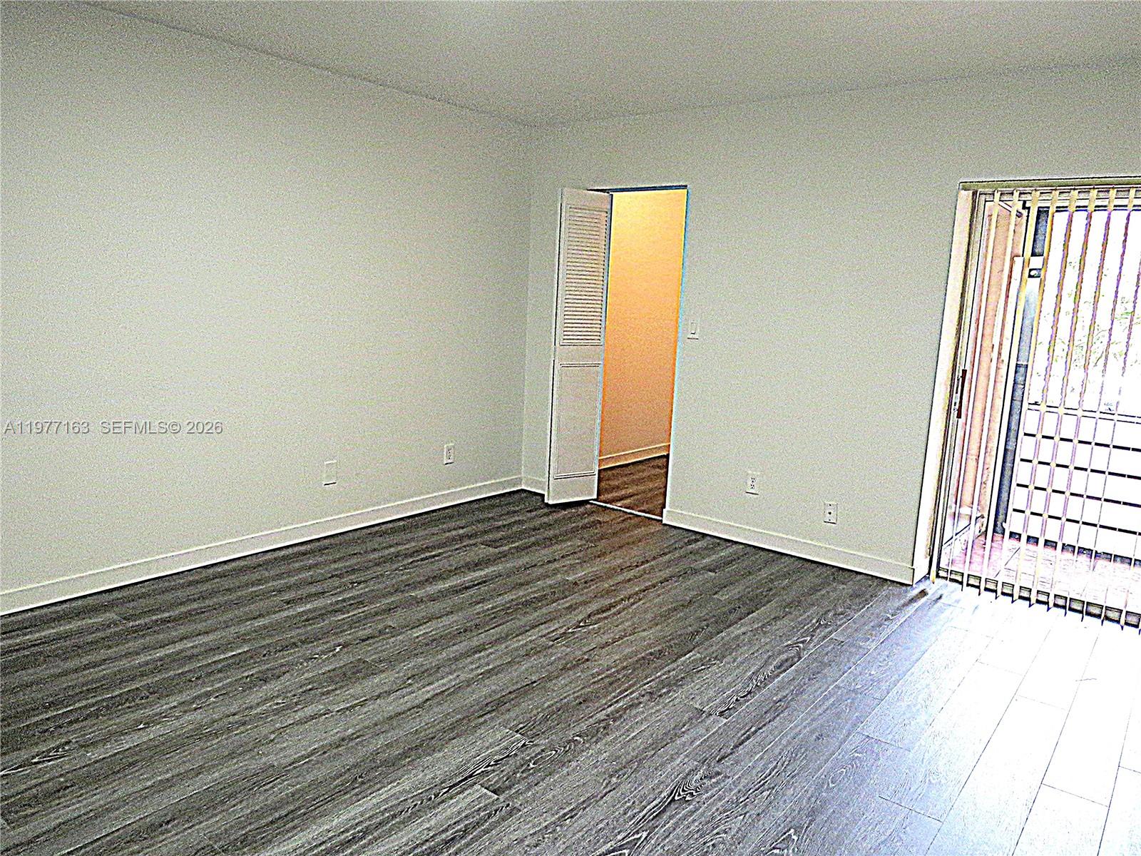 3591 Inverrary Drive, Unit 203 Lauderhill, FL 33319 - Photo 7 of 12 an empty room with wooden floor and windows