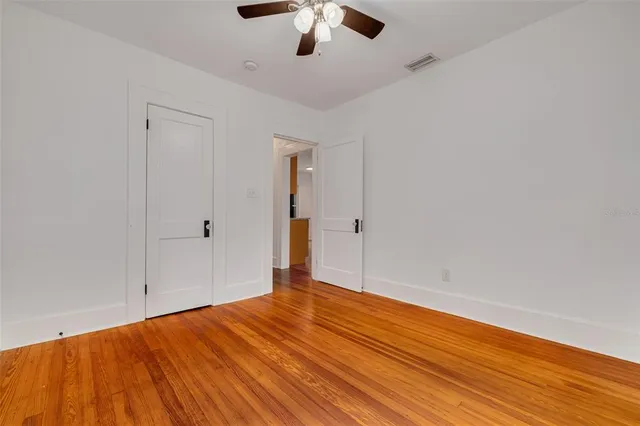 a view of empty room with wooden floor