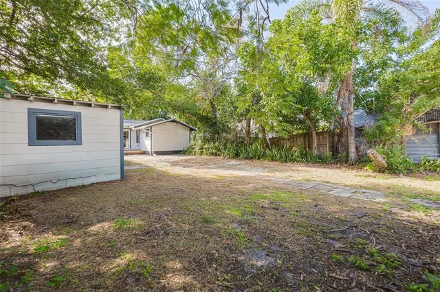 a backyard of a house with table and chairs