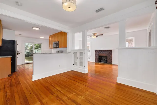 a view of a workspace with wooden floor and a fireplace