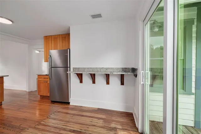 a view of a hallway with wooden floor and door