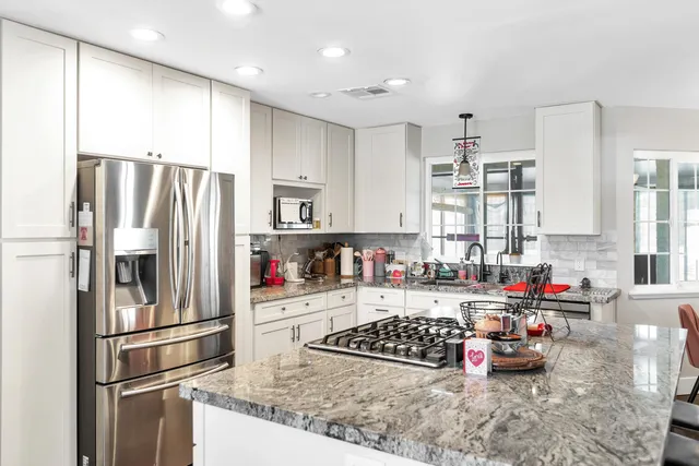 a kitchen with stainless steel appliances a refrigerator sink and cabinets
