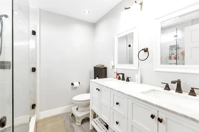 a bathroom with a double vanity sink toilet and shower