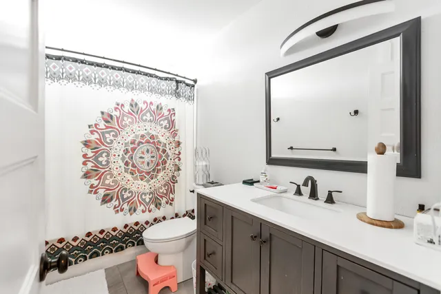 a bathroom with a sink vanity mirror and toilet