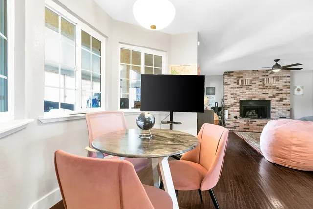 a dining room with furniture a fireplace and a flat screen tv