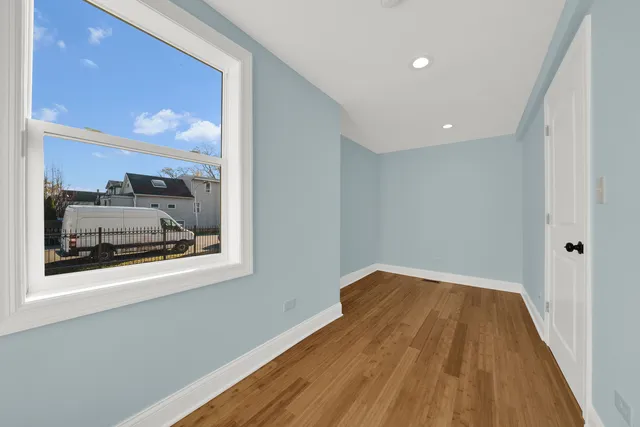 a view of a hallway with wooden floor and a bathroom sink