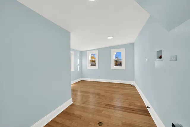 a view of an empty room with wooden floor