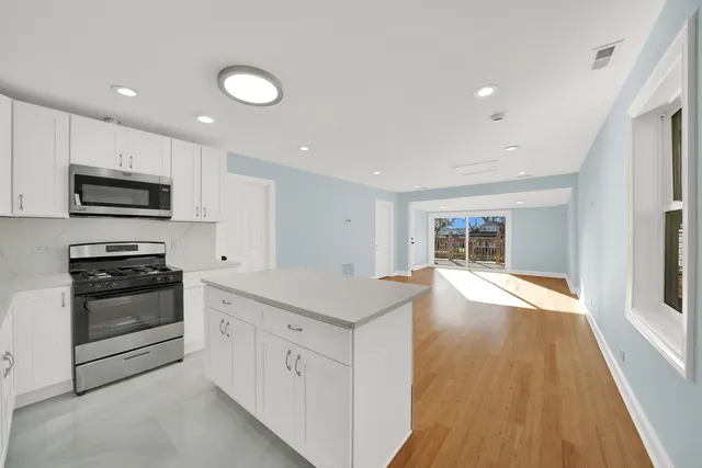 a kitchen with stainless steel appliances granite countertop a stove a sink and a refrigerator