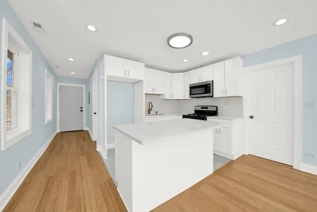a kitchen with cabinets and a wooden floor