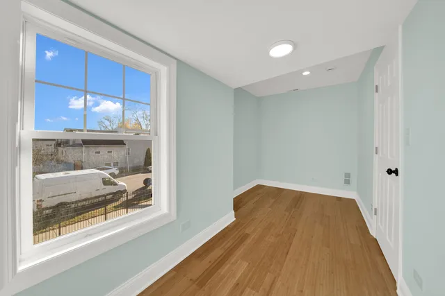 a view of a room with wooden floor and window