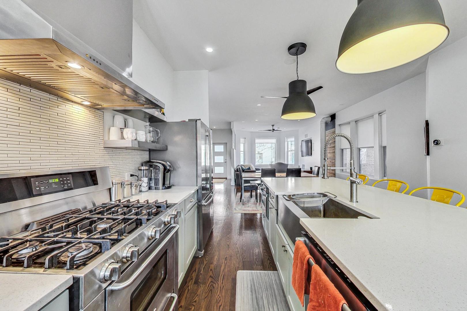 2445 West Rice Street Chicago, IL 60622 - Photo 12 of 46 a kitchen with stainless steel appliances granite countertop a sink a stove and a wooden floors