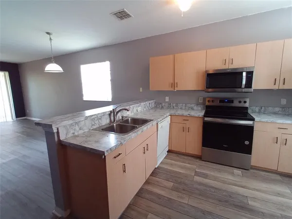 a kitchen with a sink stove and refrigerator