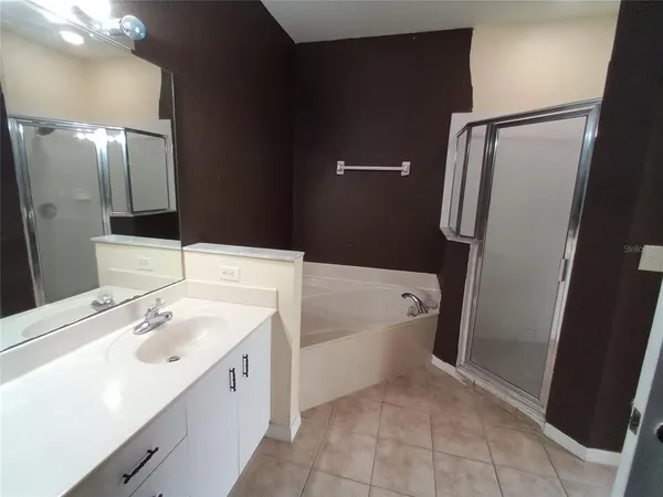 a spacious bathroom with a bathtub sink and mirror