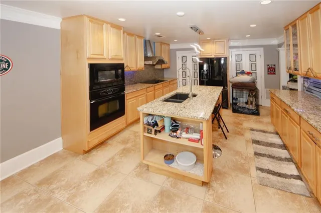 a kitchen with stainless steel appliances kitchen island granite countertop a stove and a sink