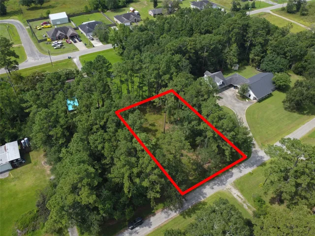 an aerial view of residential houses with outdoor space and trees