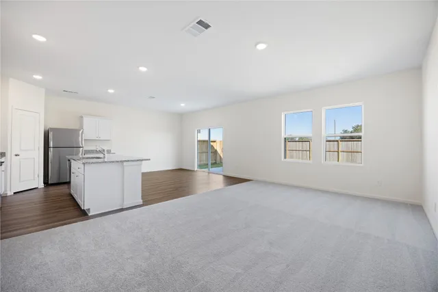 a view of empty room with kitchen and window