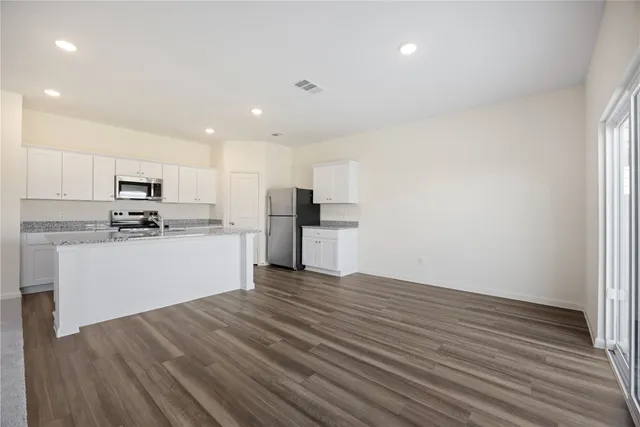 a kitchen with wooden floors and white appliances