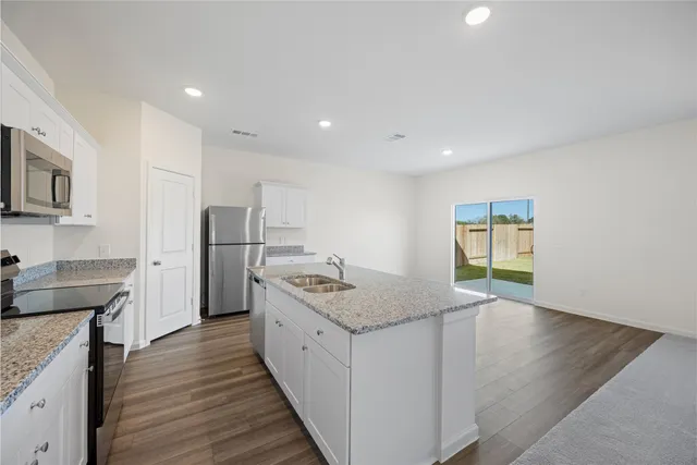 a kitchen with stainless steel appliances granite countertop a sink and a stove top oven
