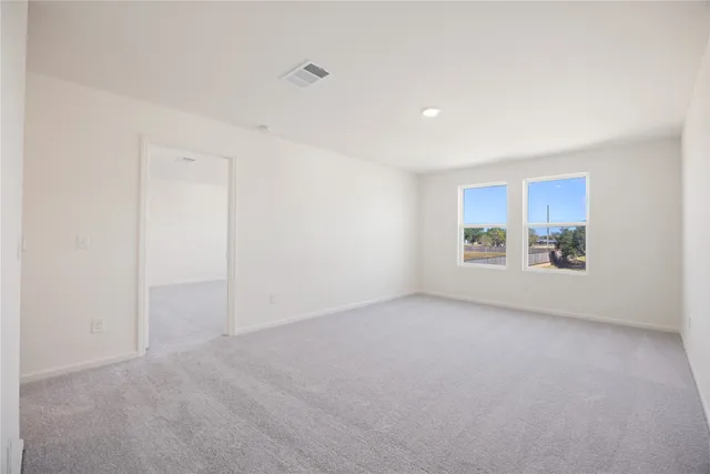 a view of a livingroom with an empty space and a refrigerator