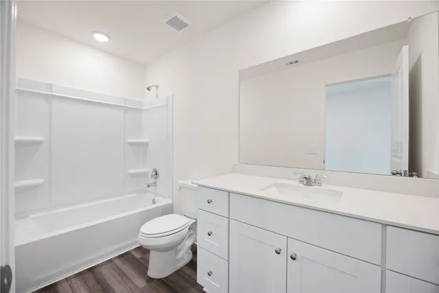 a bathroom with a toilet a sink a mirror and a bathtub