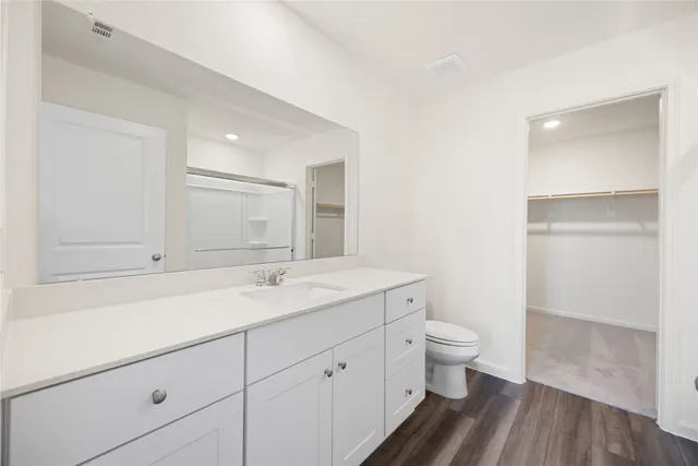 a bathroom with a sink a toilet and a large mirror