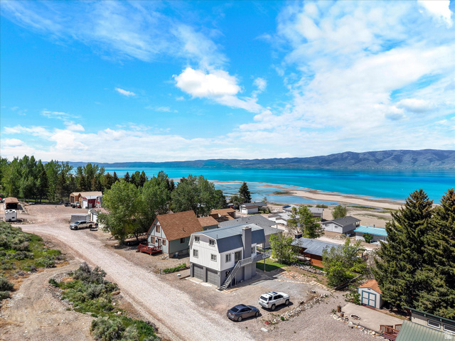 85 B Street, Unit 22 St. Charles, ID 83272 - Photo 11 of 35 Aerial perspective showcasing a two-story residence with a gray exterior and attached two-car garage, view of water and mountains