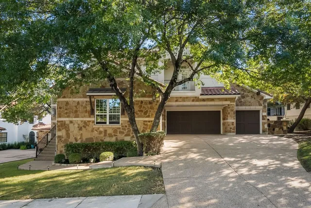 a front view of a house with yard and tree