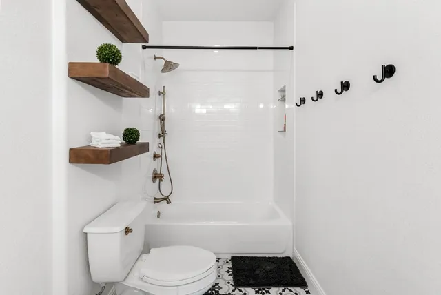 a bathroom with a toilet and a shower
