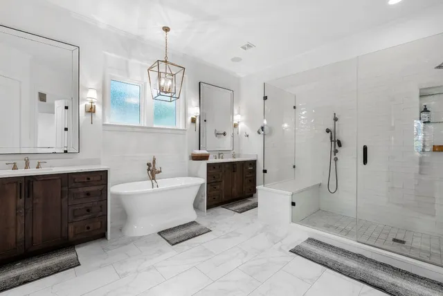 a spacious bathroom with a tub sink shower and mirror