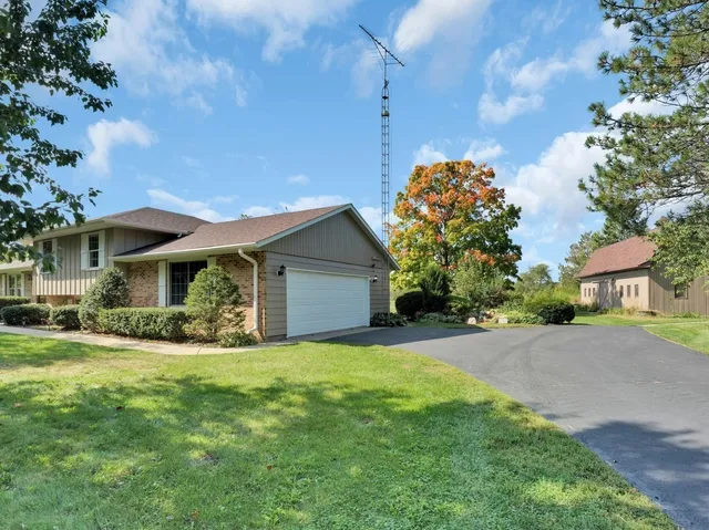 a front view of house with yard and trees in the background
