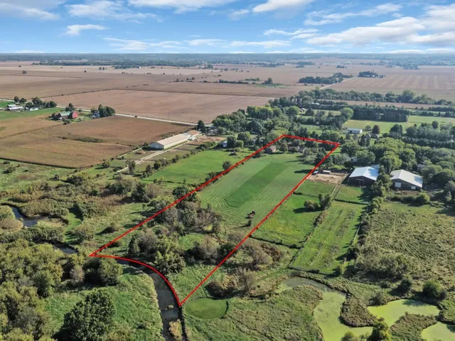 a aerial view of a house next to a big yard and large trees