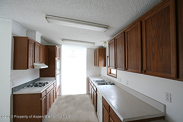 100 Ray Avenue Rifle, CO 81650 - Photo 3 of 9 a kitchen with granite countertop a stove and a refrigerator