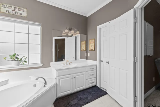 a spacious bathroom with a tub sink and mirror