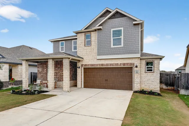 a front view of a house with a yard and garage
