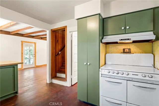 a view of a kitchen with fridge and wooden floor